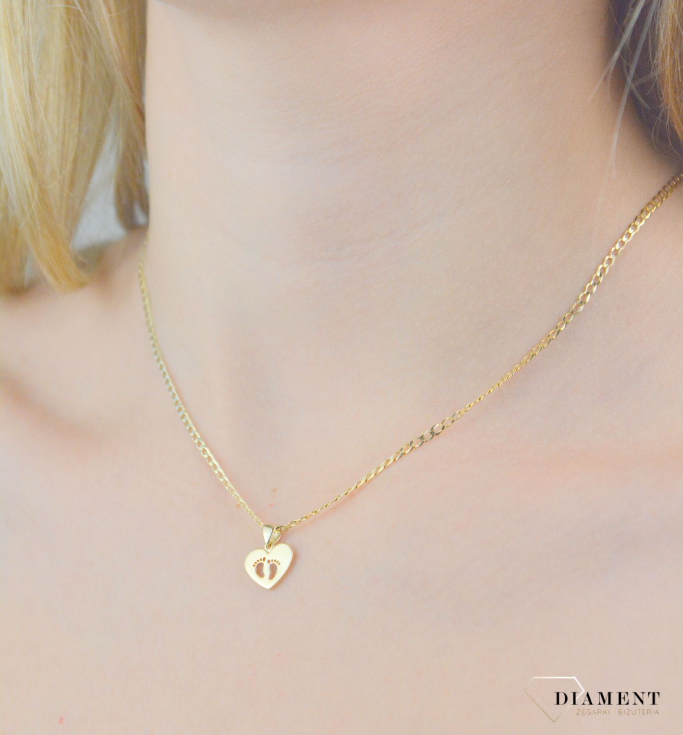 Zawieszka złota stópki próba 585, ZA 7935 585 Piękny, złoty wisiorek o ciekawym wzorze wykonany z żółtego 14-karatowego złota. Zawieszka w formie serca. Wisiorek został wykonany z wysokiej jakości złota próby 585. 2.jpg